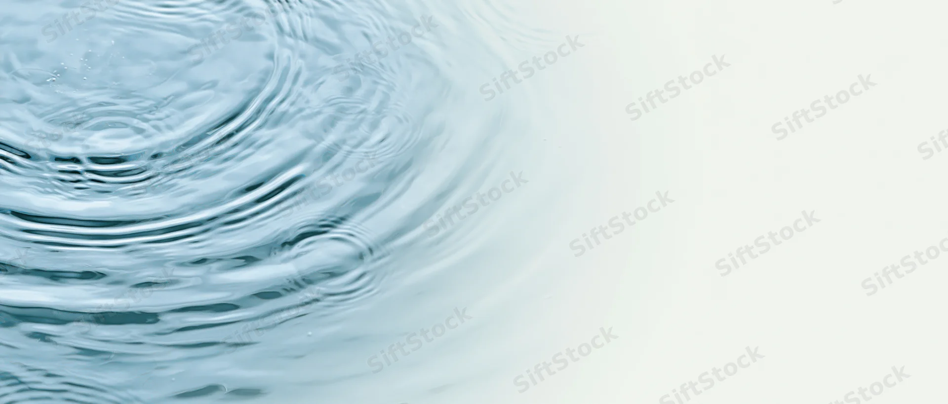 Rippling water surface with concentric circles and light gradient background
