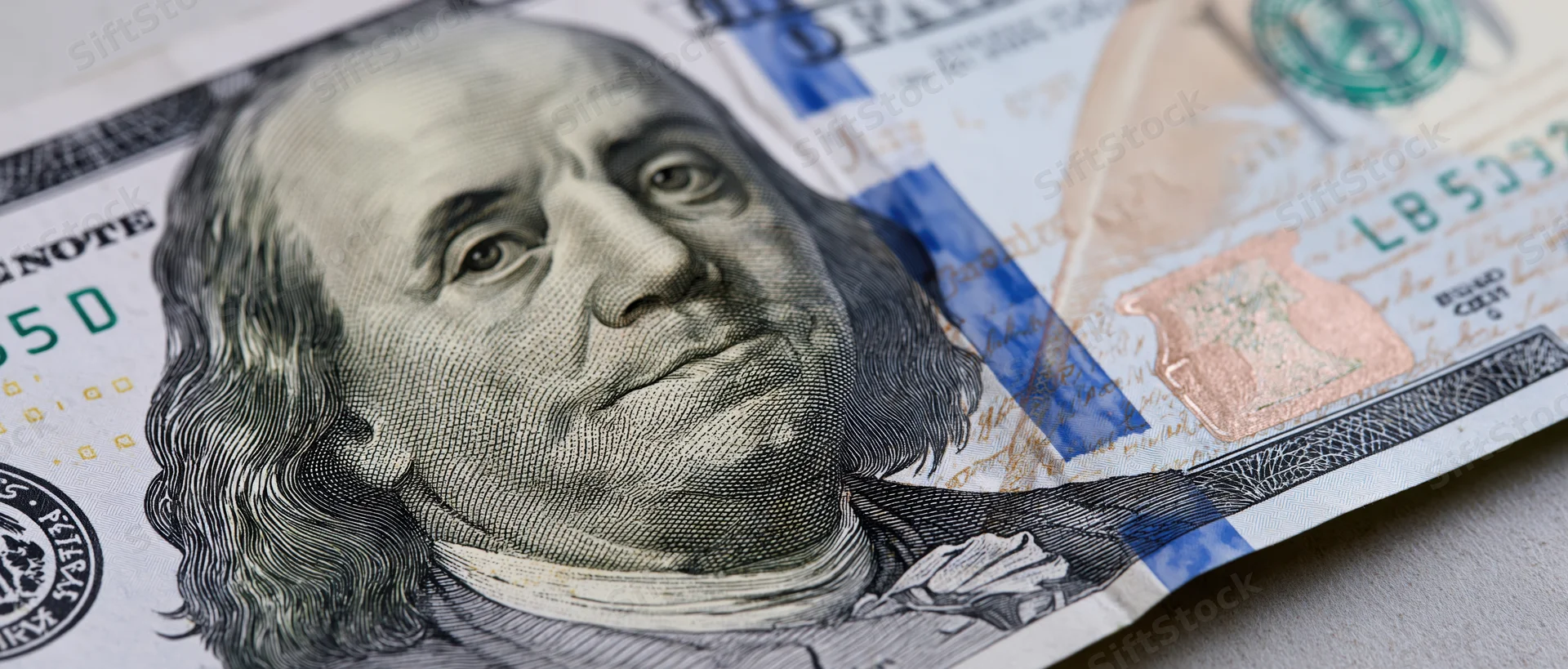 Close-up of a us hundred dollar bill spread flat on a surface