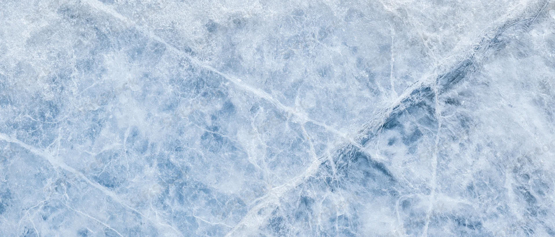 Close-up of natural ice surface with cracks and frost patterns filling the frame