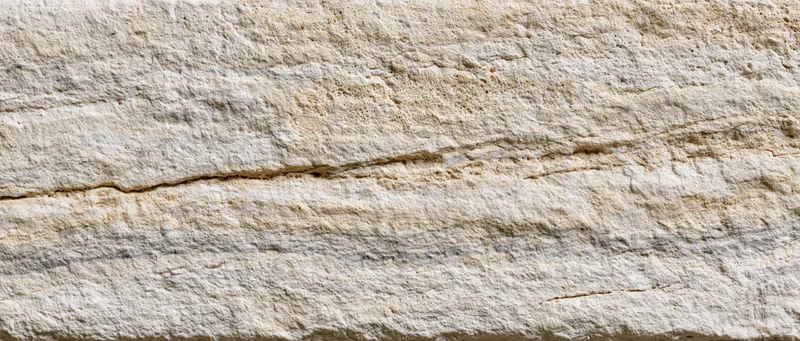 Close-up of natural limestone surface showing layered texture and cracks