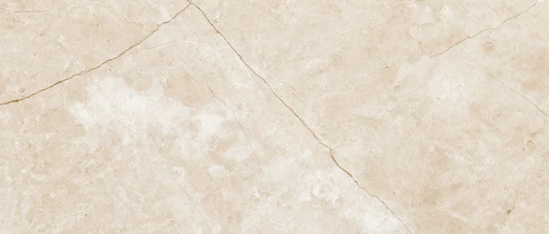 Close-up of a polished cream marble slab surface with natural veining and texture