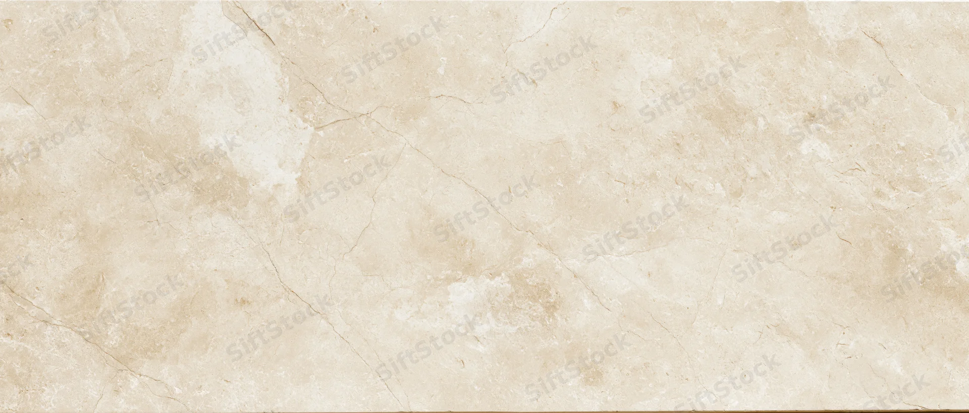 Close-up of a polished cream marble slab surface with natural veining and texture