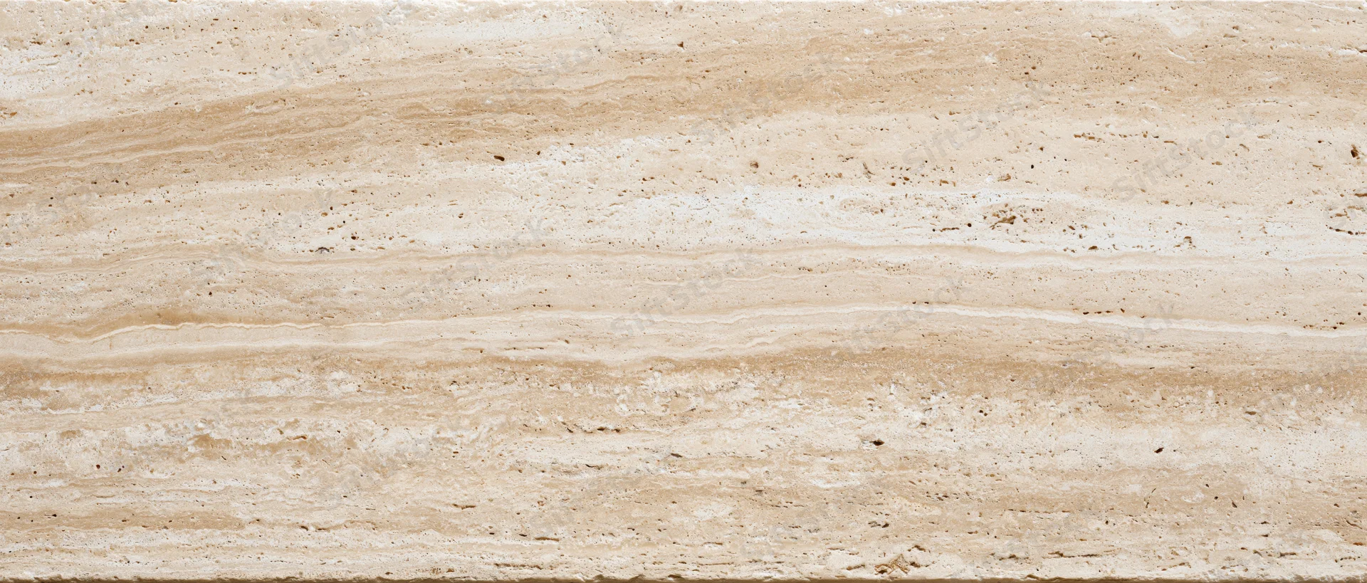 Close-up of a polished travertine stone surface with natural veining and layered texture