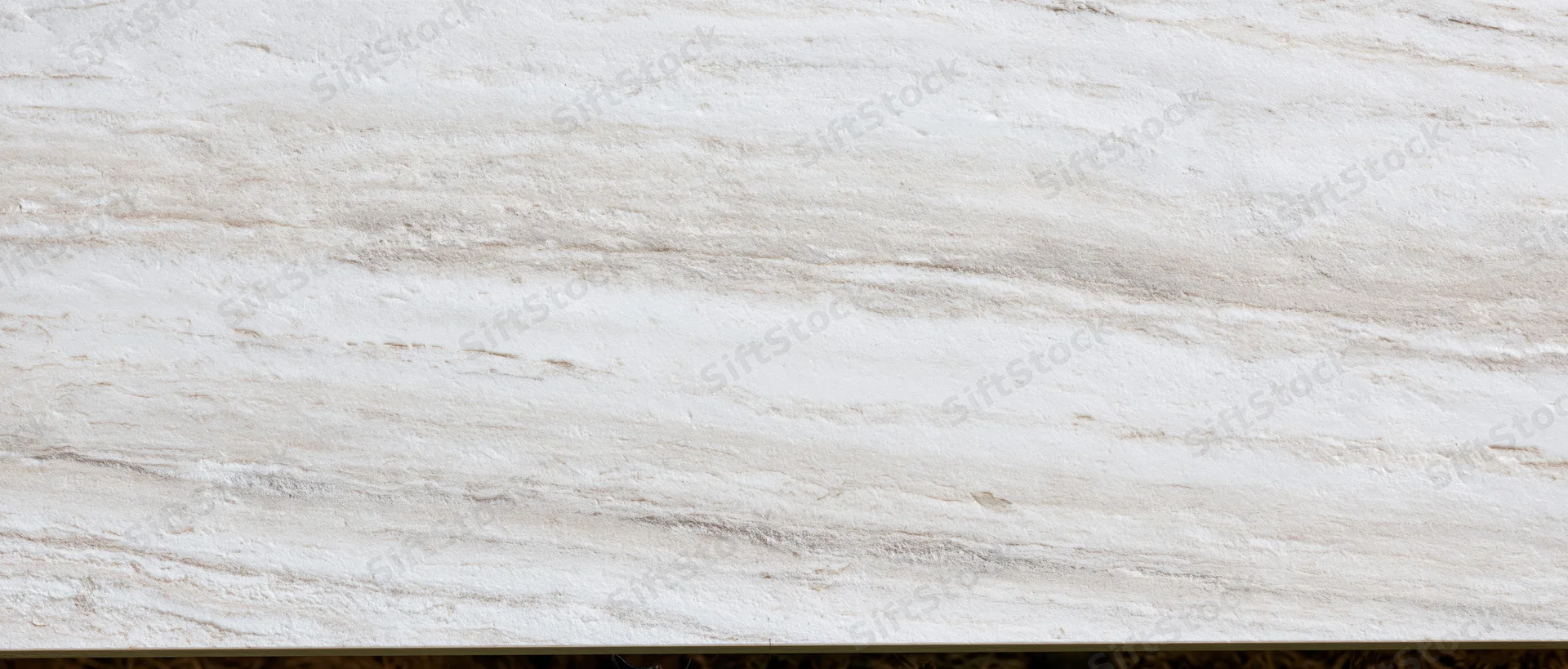 Close-up of a polished white marble slab surface with natural veining and smooth texture