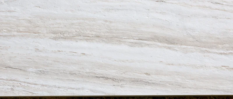 Close-up of a polished white marble slab surface with natural veining and smooth texture