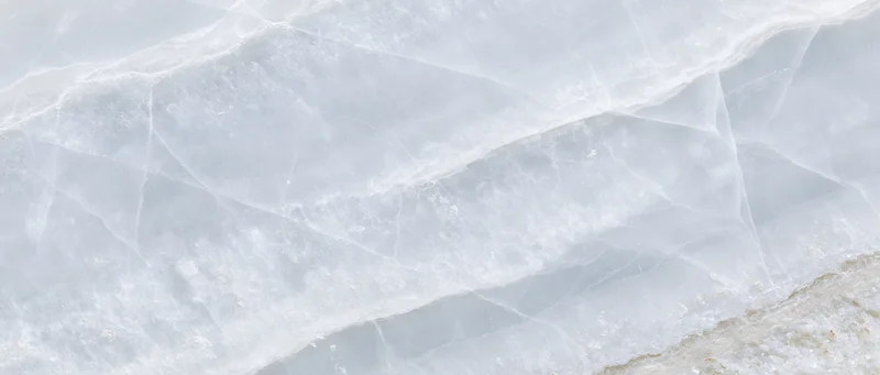 Close-up of a polished white onyx marble slab surface with natural veining and lustrous texture