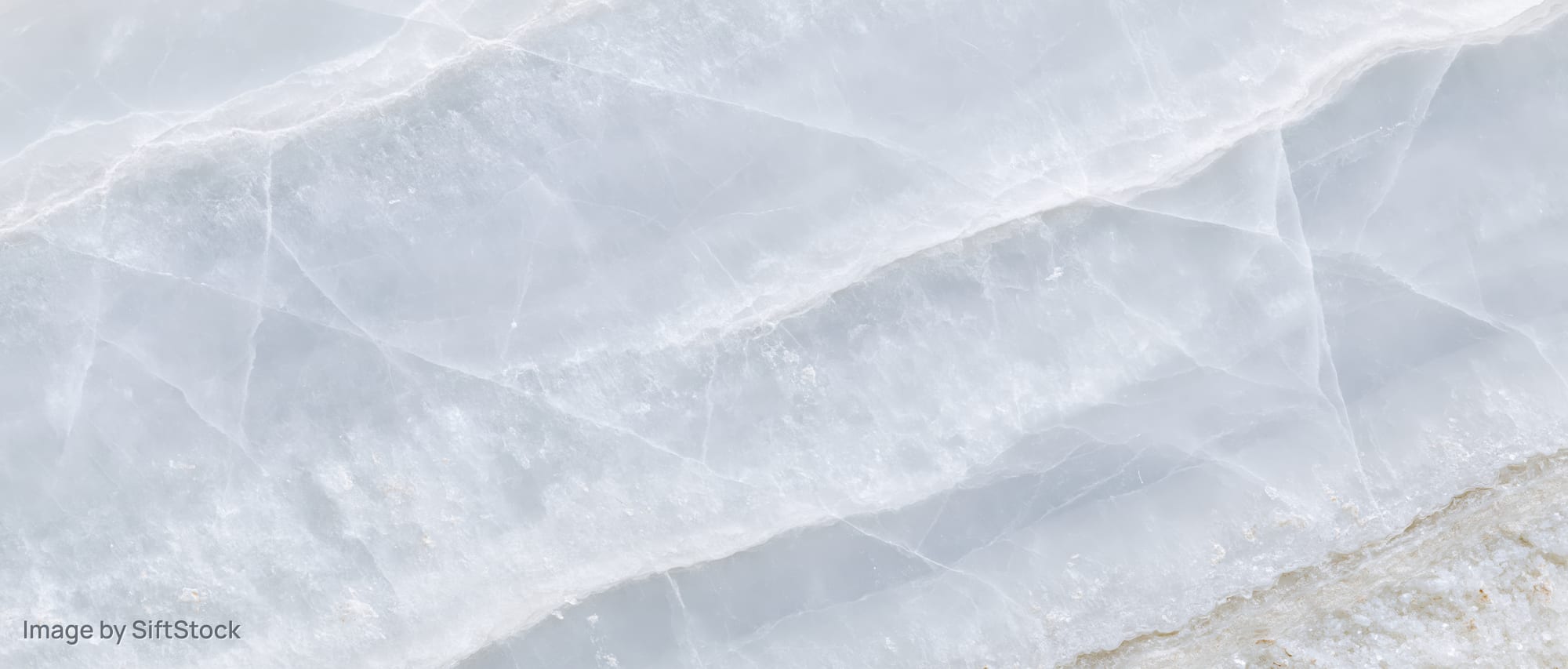 Close-up of a polished white onyx marble slab surface with natural veining and lustrous texture
