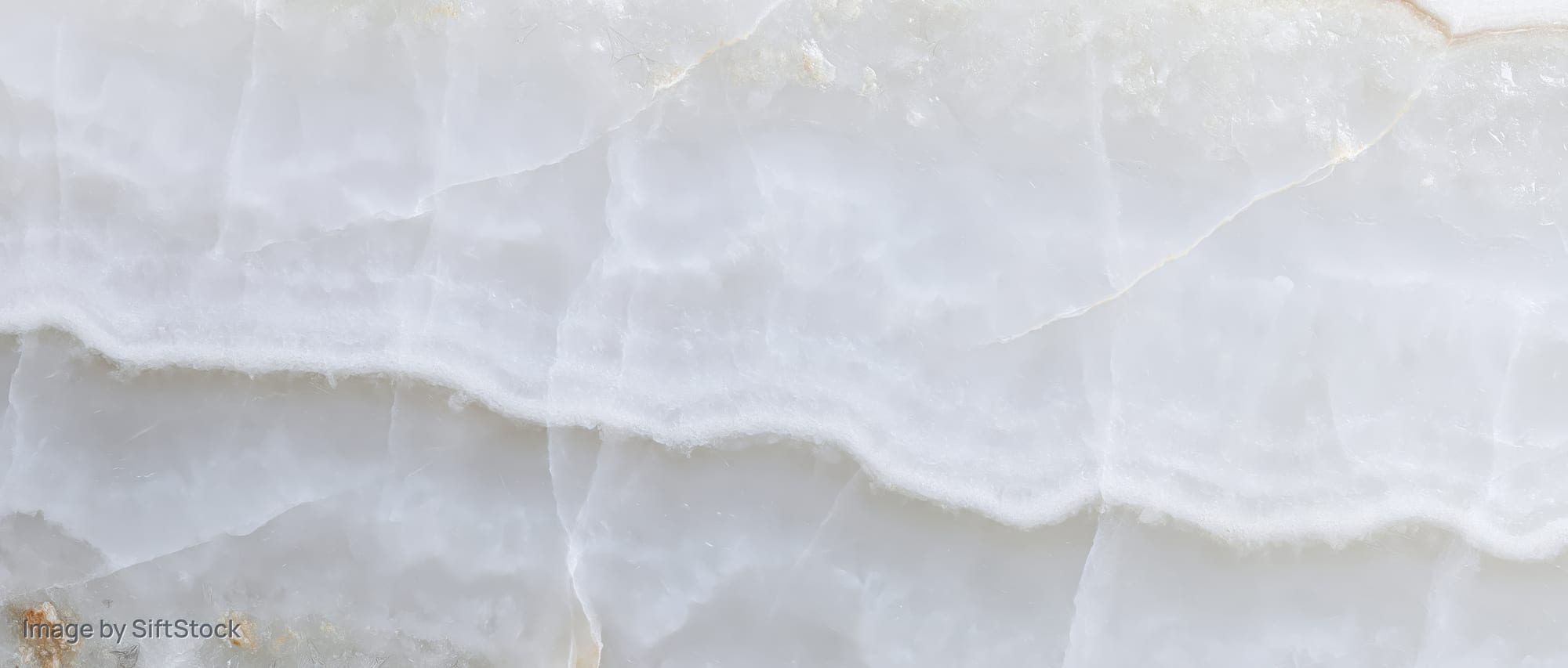Close-up of polished white onyx marble slab surface showing natural veined texture and layered pattern