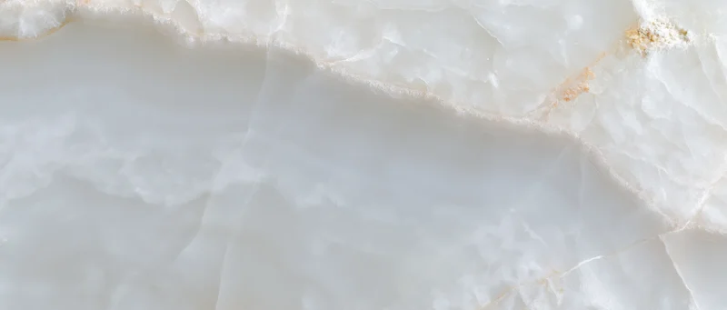 Close-up of a polished white onyx marble slab surface with natural veining and translucent texture