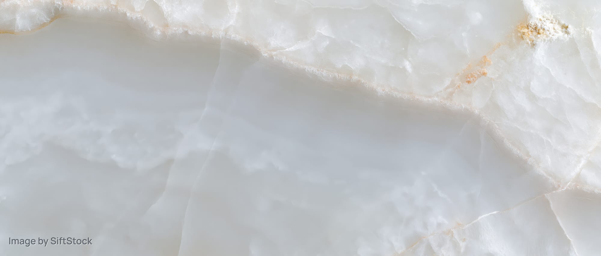 Close-up of a polished white onyx marble slab surface with natural veining and translucent texture