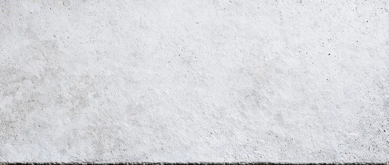 Close-up of a raw concrete wall surface with rough texture and gray tone