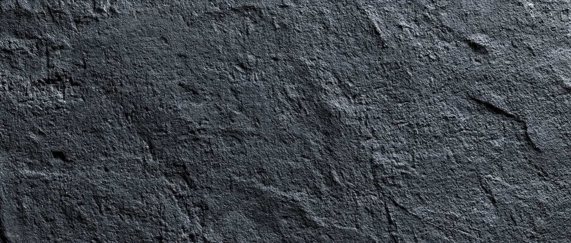 Close-up of rough dark concrete wall surface