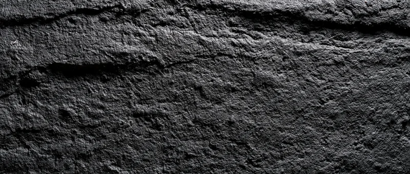 Close-up of rough dark concrete wall surface