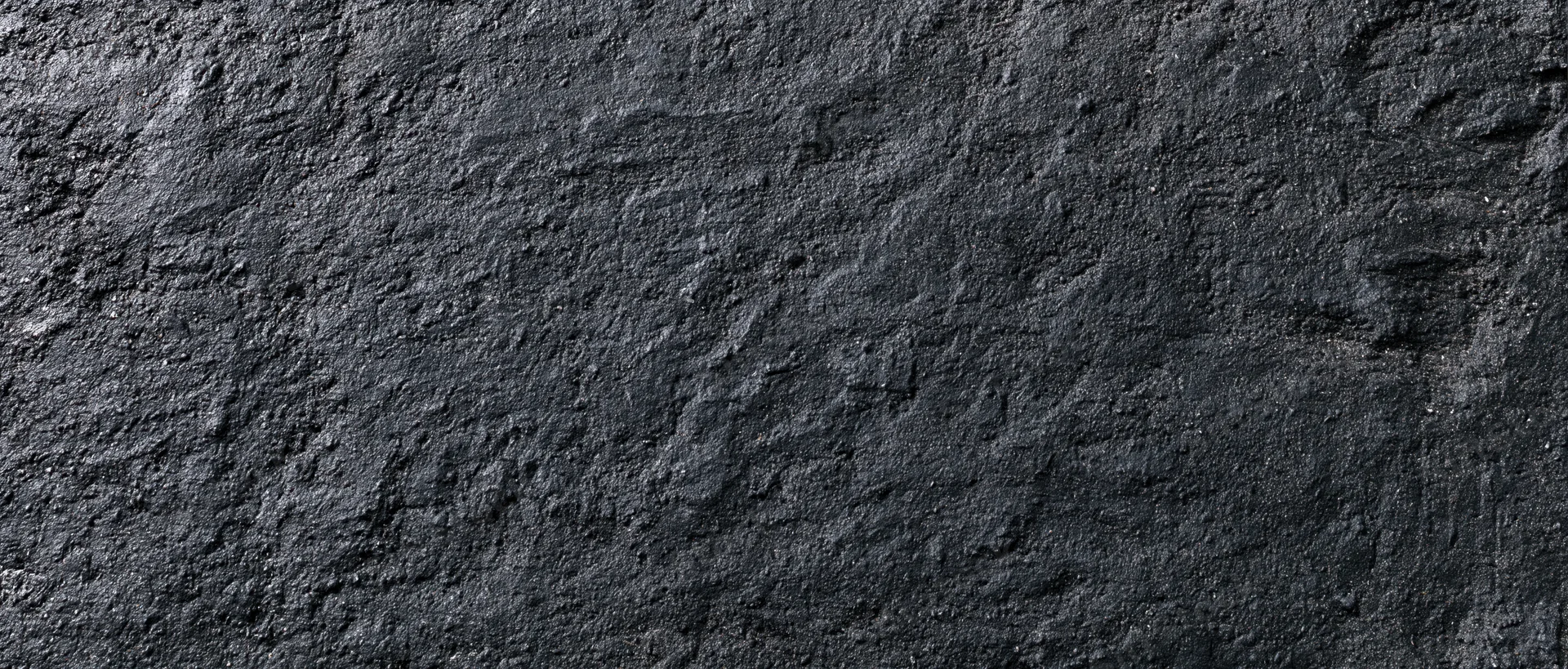 Close-up of rough dark concrete wall surface