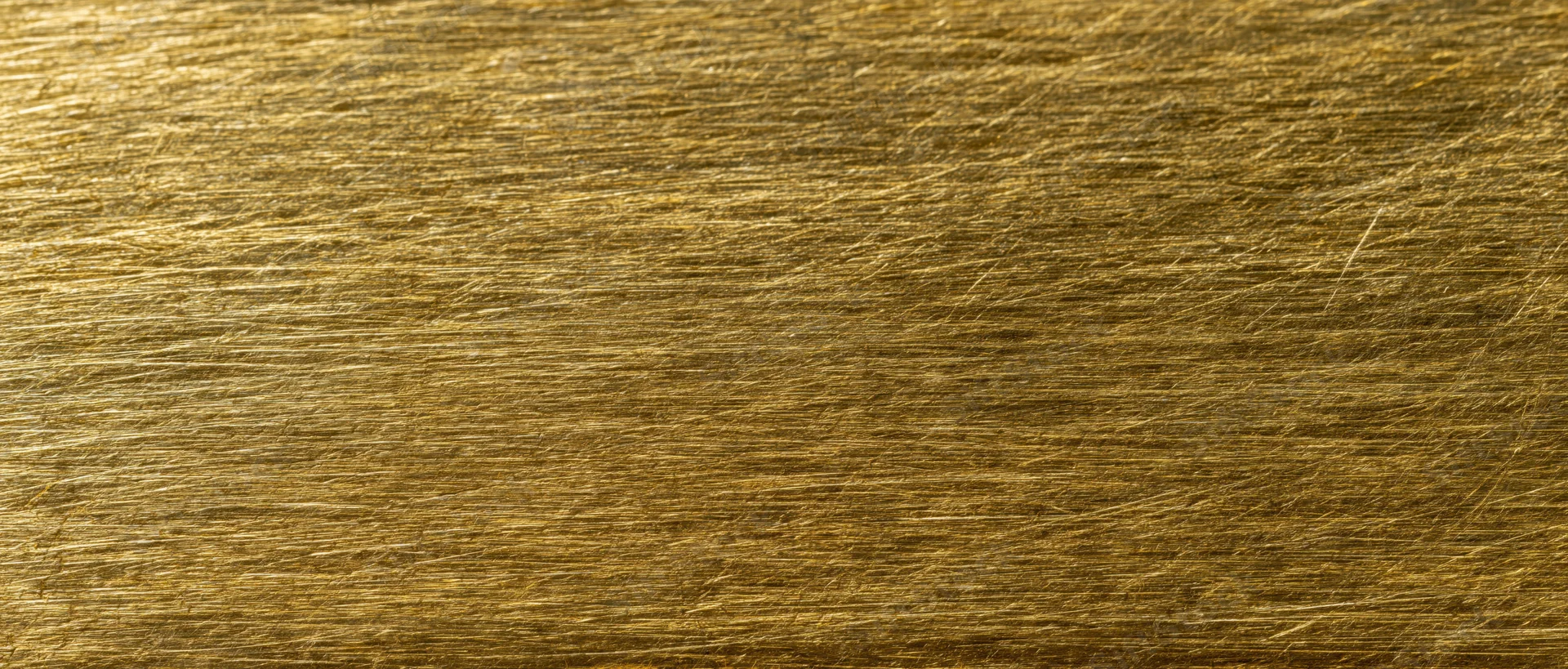 Close-up of scratched gold metal surface filling the frame