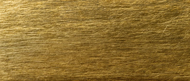 Close-up of scratched gold metal surface filling the frame