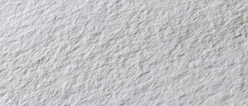 Close-up of textured white cold-press watercolor paper surface