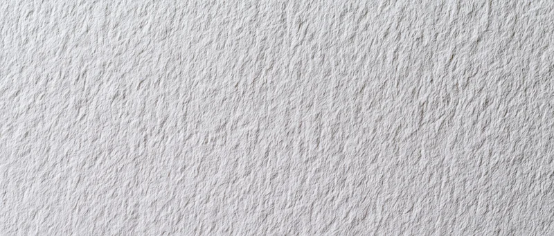 Close-up of white textured paper or linen wallpaper surface