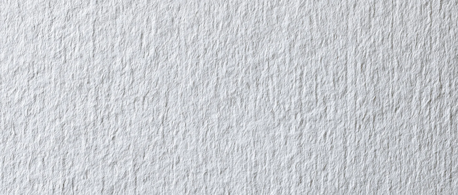 Close-up of white textured paper or linen wallpaper surface
