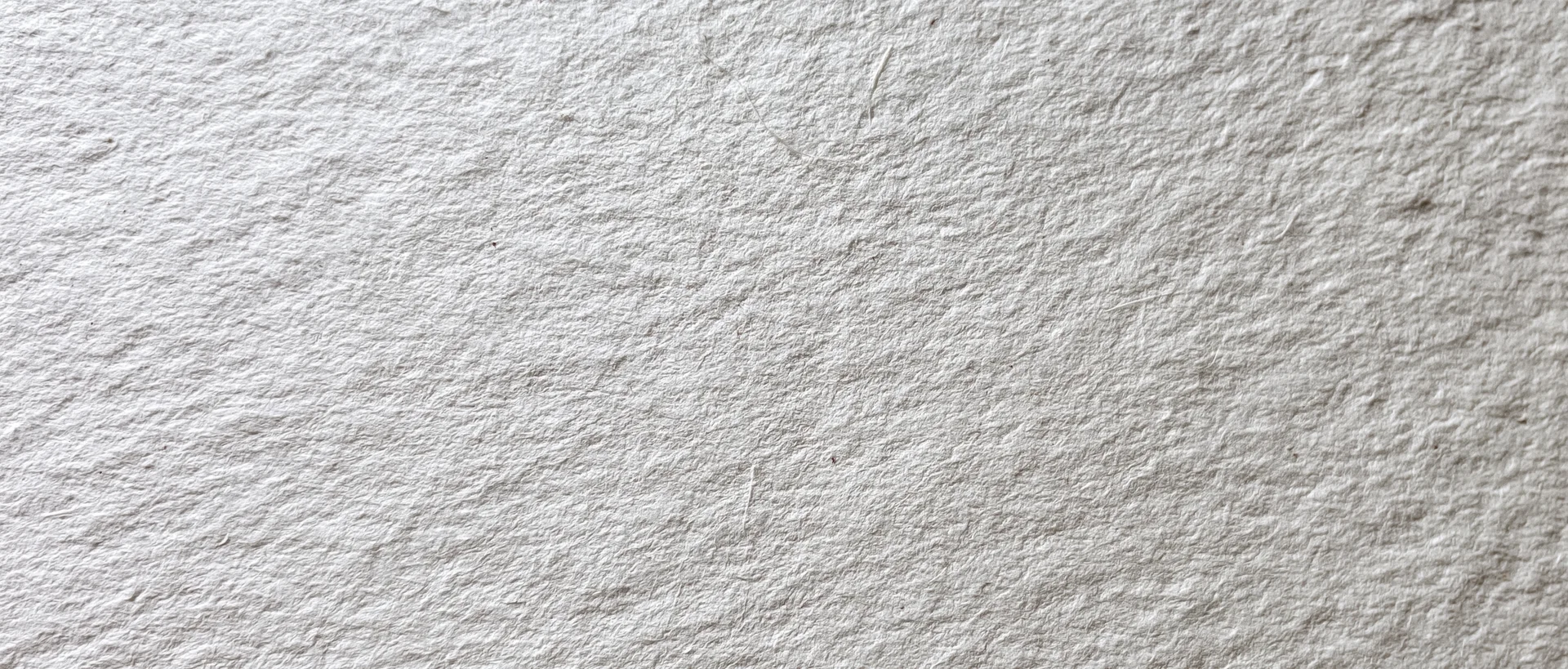 Close-up of aged white paper surface with textured grain and subtle imperfections