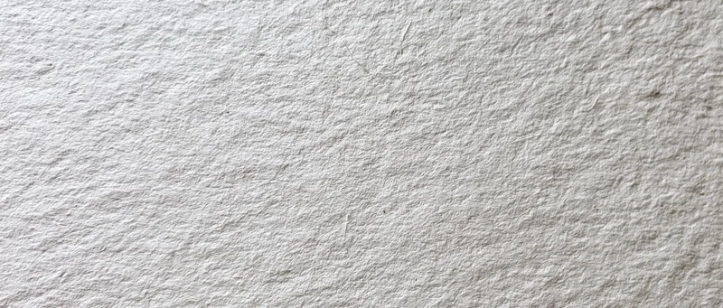 Close-up of aged white paper surface with textured grain and subtle imperfections