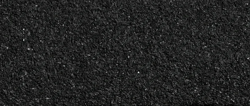Close-up of coarse dark asphalt surface with granular texture