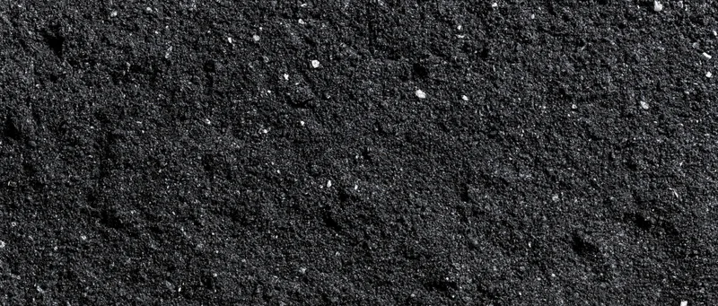 Close-up of dark asphalt surface with fine granular texture