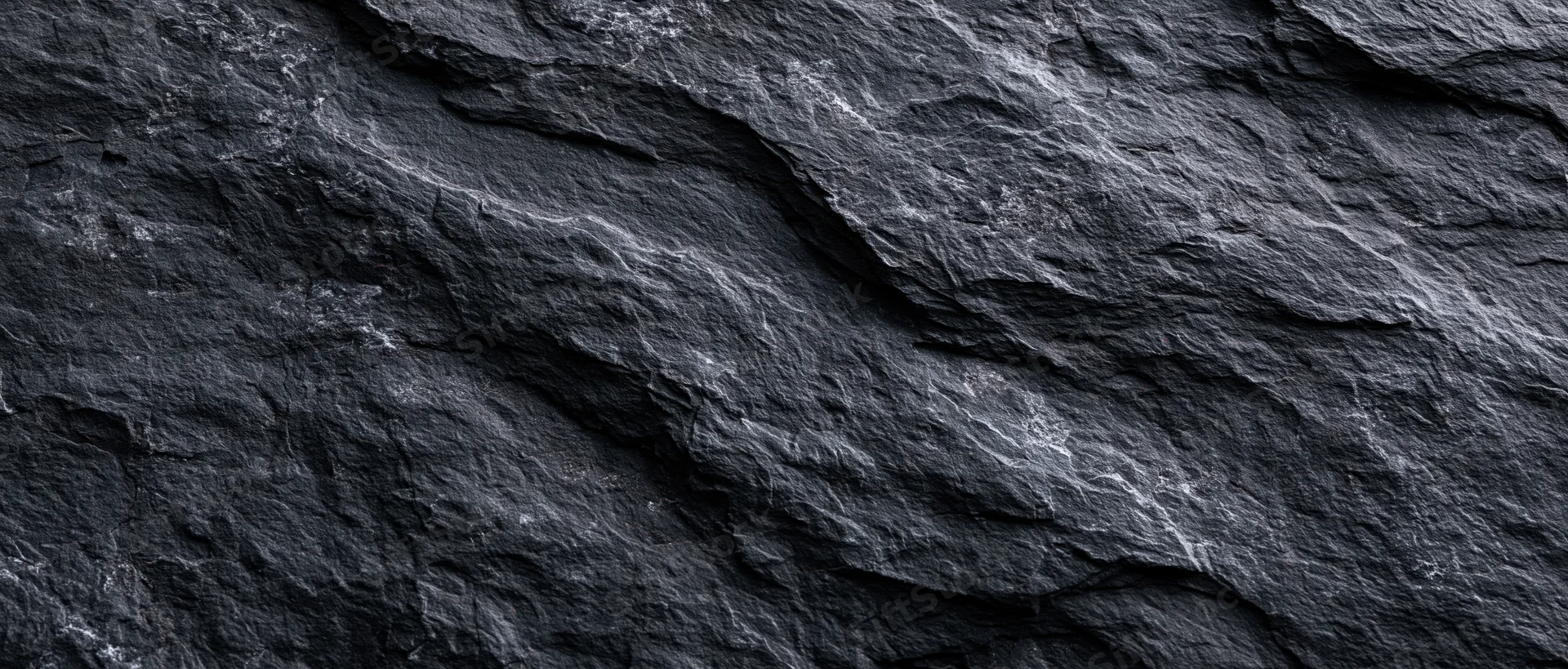 Close-up of dark slate stone surface with natural texture and layered patterns
