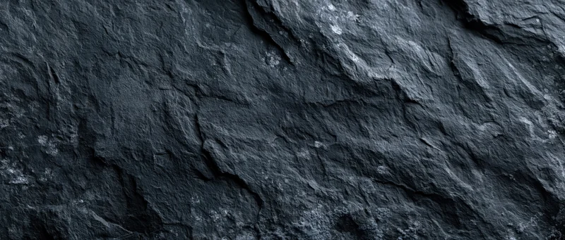Close-up of dark slate stone surface with natural cracks and layers