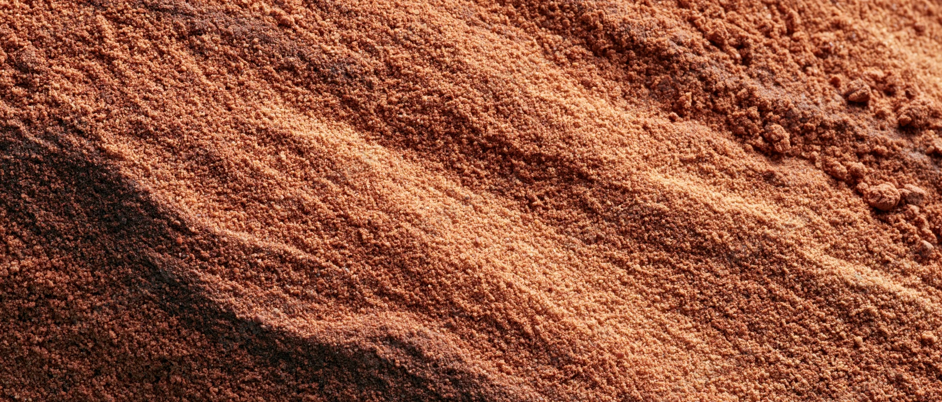 Closeup of coarse dry sand surface with visible texture and layers