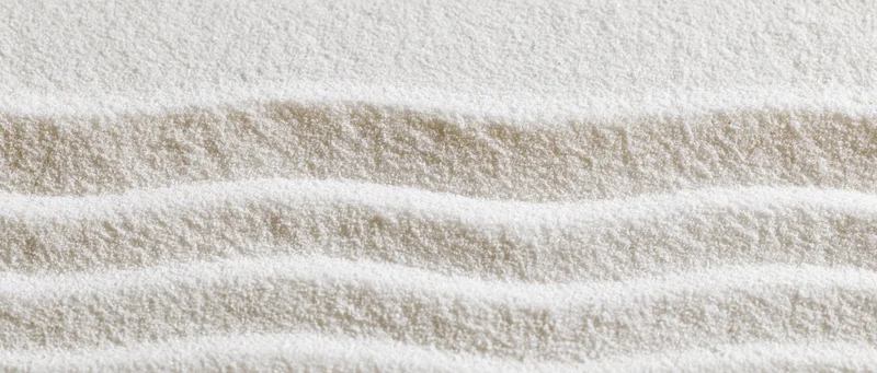 Raked white sand in a zen garden forming parallel lines and stripes