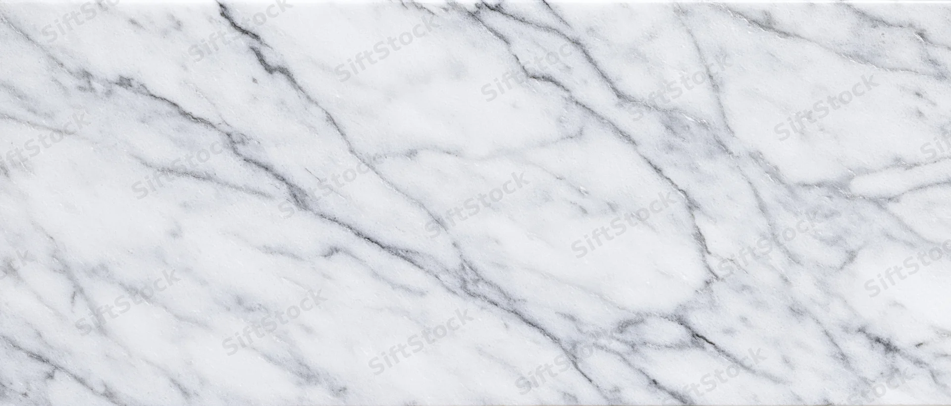 Close-up of white carrara marble surface with gray veining filling the frame