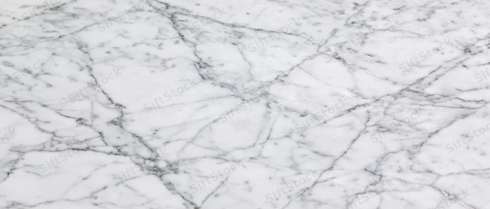 Close-up of white carrara marble surface with gray veining filling the frame