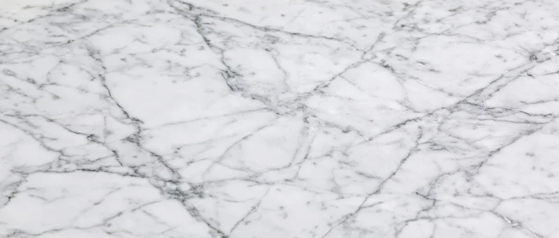 Close-up of white carrara marble surface with gray veining filling the frame