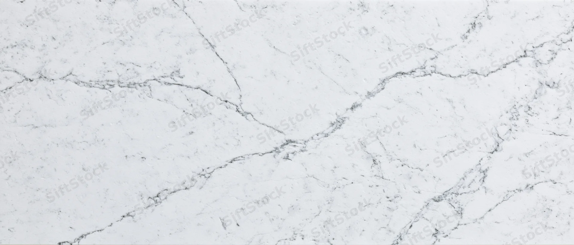 Close-up of white carrara marble surface with natural veining pattern