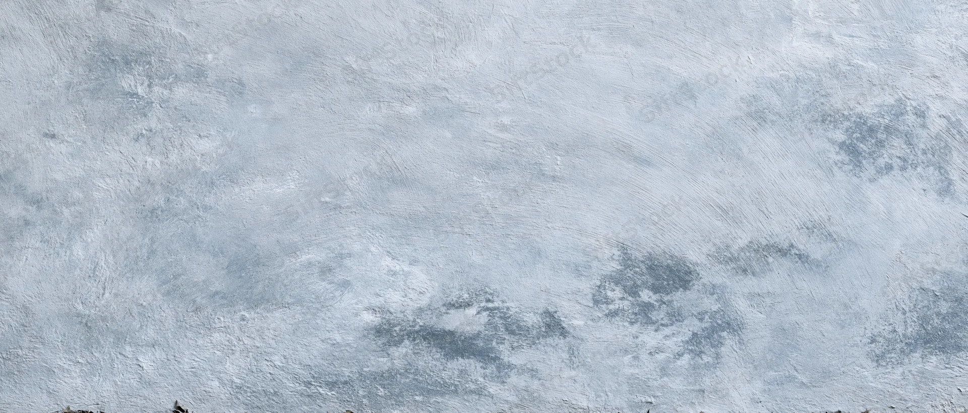 Close-up of a weathered concrete wall surface with rough texture and gray tones