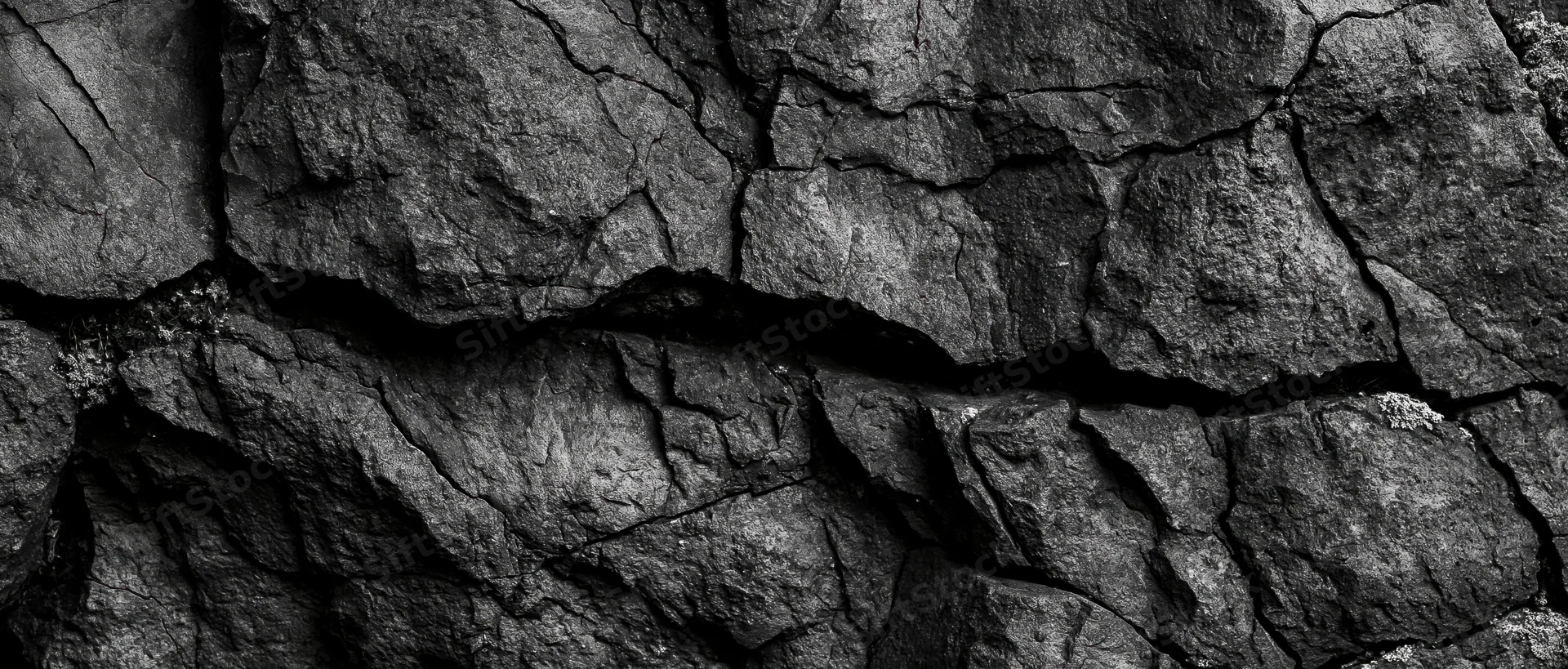 Close-up of cracked basalt rock surface showing natural fractures and rough texture