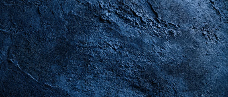 Close-up of a rough blue plastered concrete wall surface