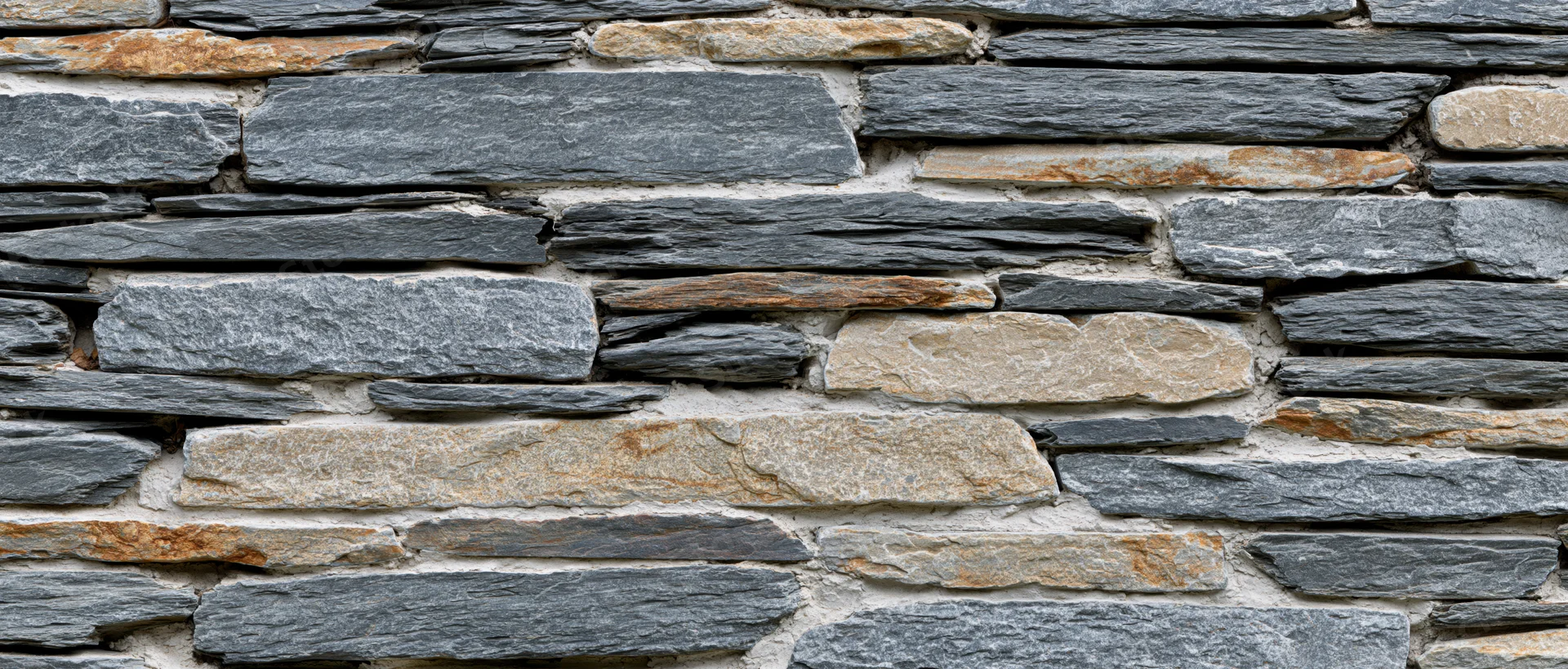 Close-up of stacked slate stone wall covering an exterior surface