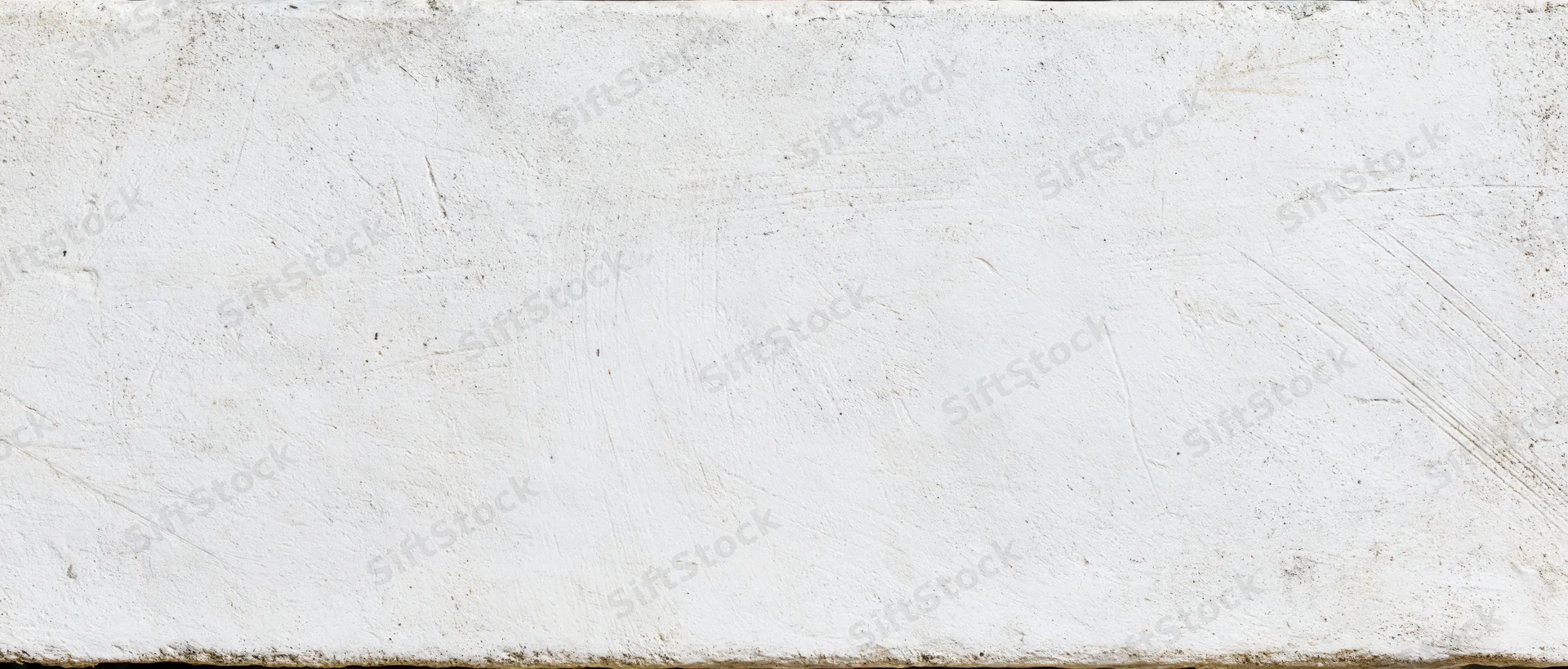 Weathered white concrete wall surface with visible texture and imperfections