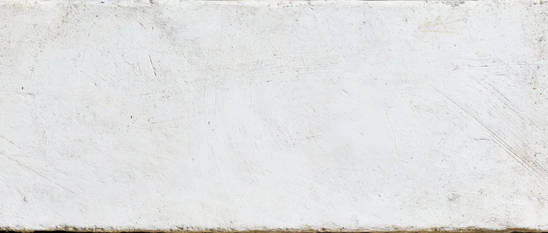 Weathered white concrete wall surface with visible texture and imperfections