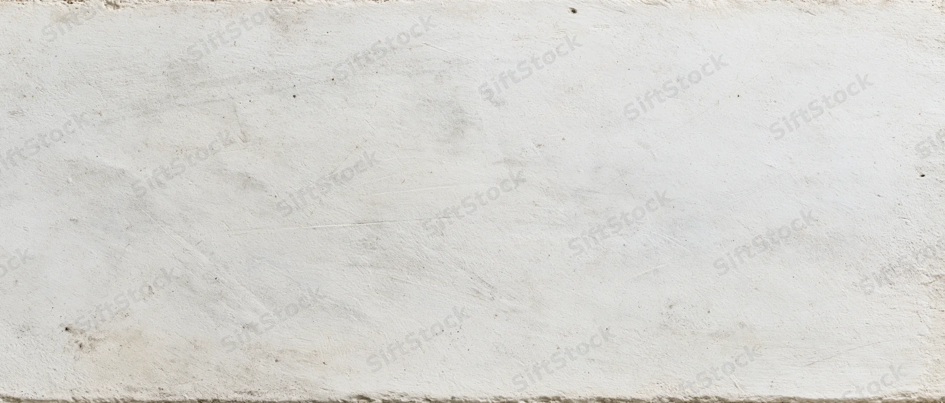 Weathered white concrete wall surface with rough texture and subtle discoloration