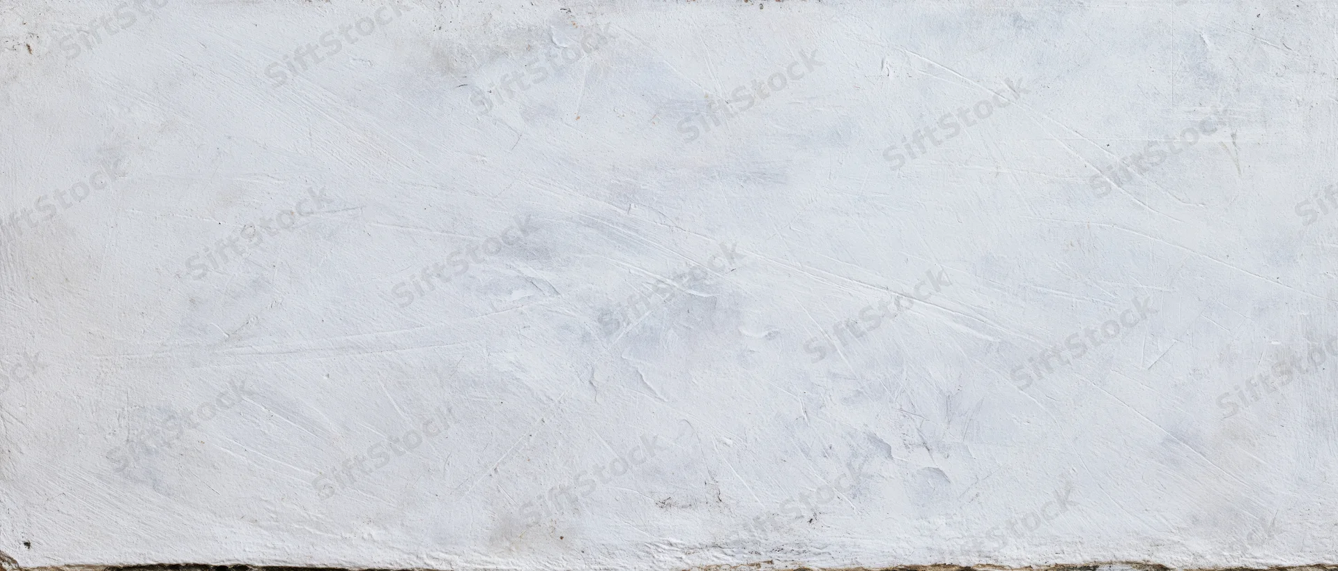 Weathered white concrete wall surface with visible texture and cracks