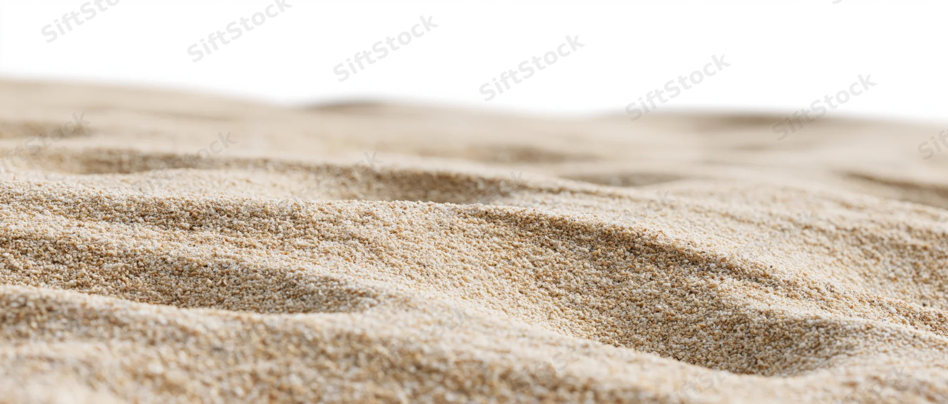 Close-up of dry beach sand with wind-formed ripples on a white background