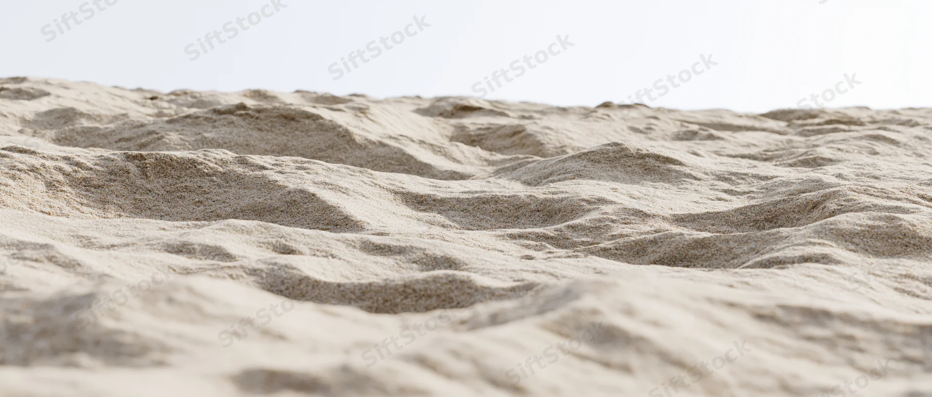 Closeup of dry beach sand with wind-formed ripples at ground level