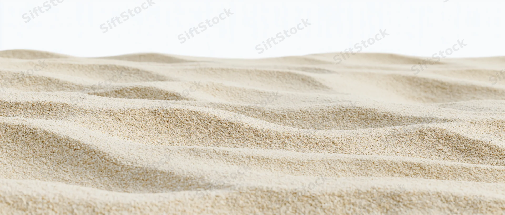 Close-up of rippled dry beach sand at ground level with smooth undulating texture