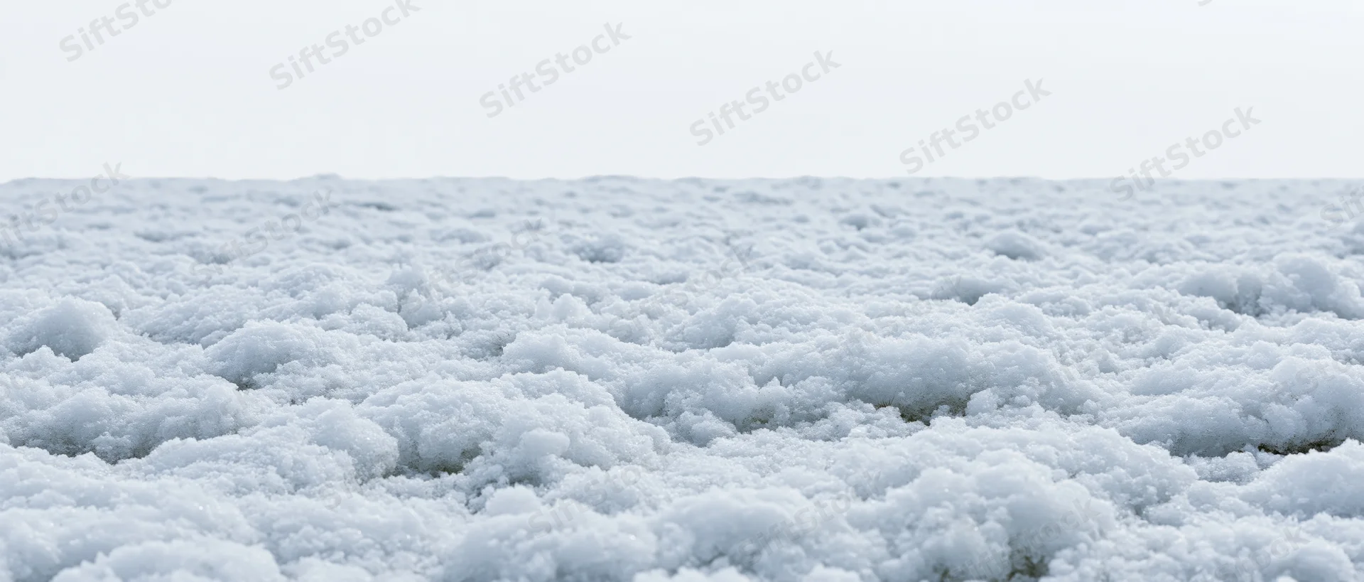 Close-up of undisturbed snow surface on the ground under overcast sky