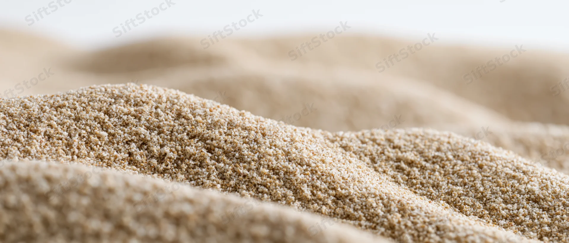 Close-up low-angle view of dry sand ripples forming undulating texture across a desert surface