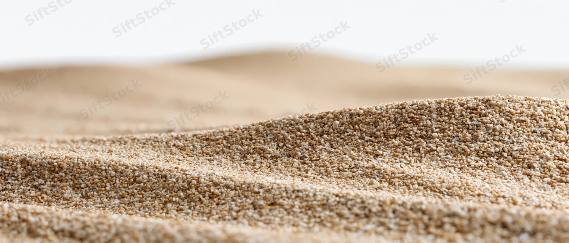 Close-up low-angle view of dry sand ripples stretching across a desert landscape