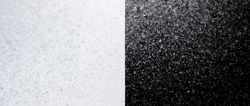Closeup of snowflakes and water droplets on contrasting white and black surfaces